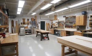 Well-lit woodworking shop with workbenches and tools