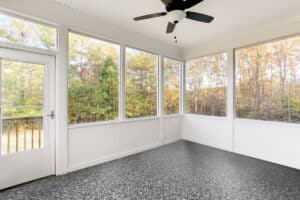 Spacious Covered Porch With A Fan Overlooking A Lush Garden And Greenery.